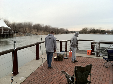 (From left) Chris West and Bill Markle were packed in tight to the corner in hopes of catching a carp swimming out of the stream that joins the Inner Harbor.