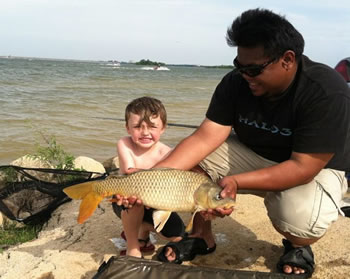 Club Director Josef Raguro helping an excited young angler handle a common carp